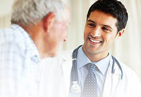 man doctor smiling at old man patient